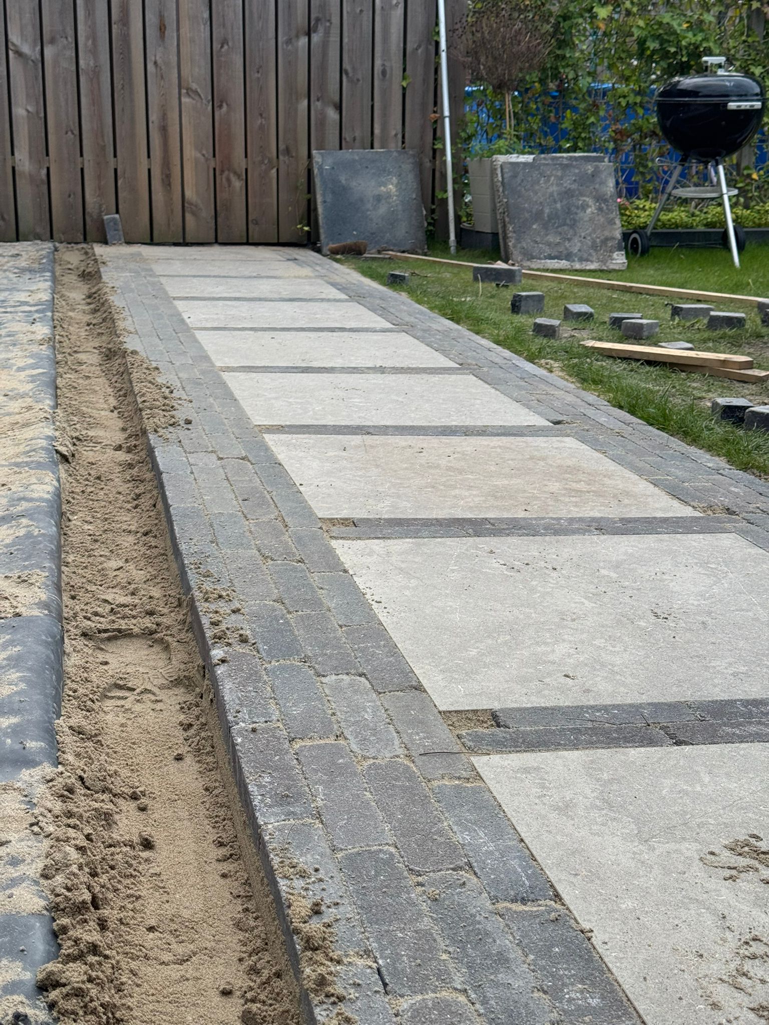 Straatwerk leggen en verdichten in de tuin